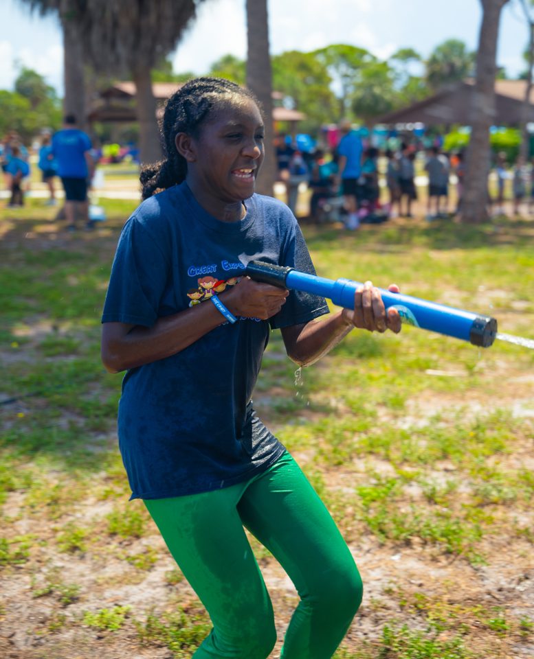 Girl with a water blaster at a summer party