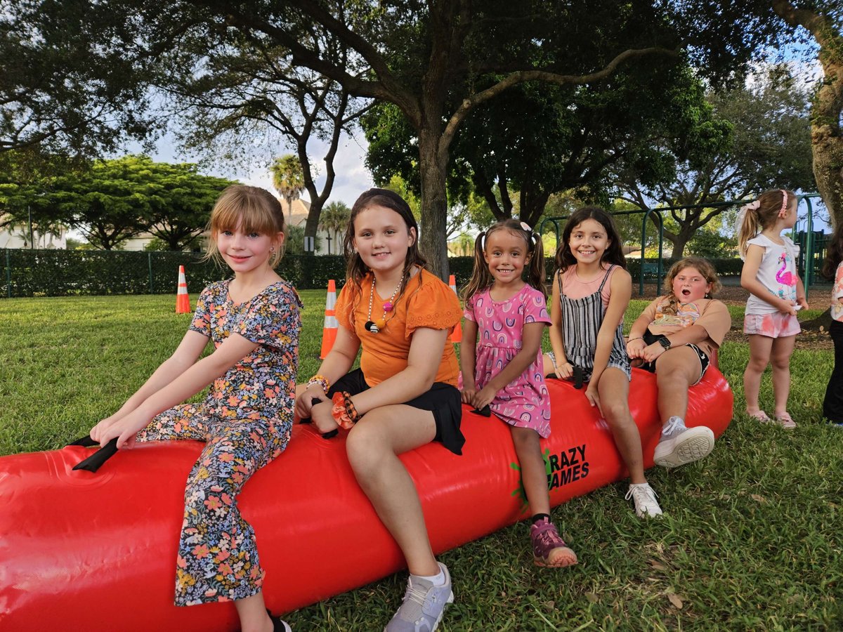 Giant inflatable pen relay race on a park field in Lake Worth Beach