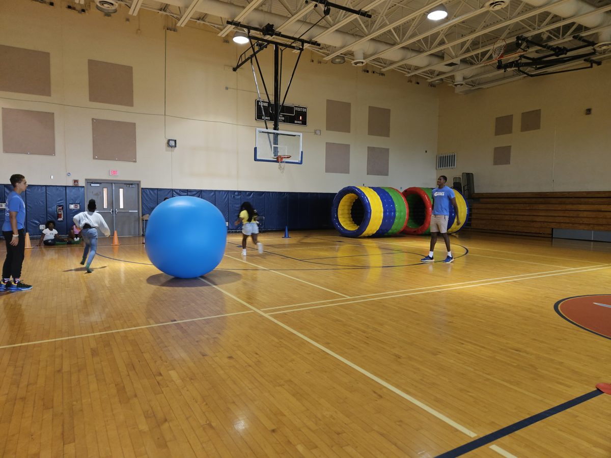 Kids playing giant push ball games in a school gym