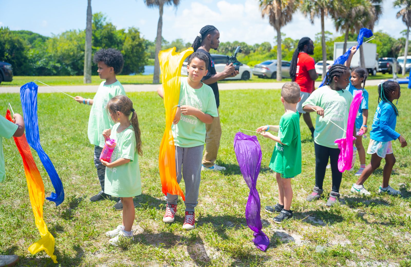 Kids with colored scarves on lawn at a Crazy Games event