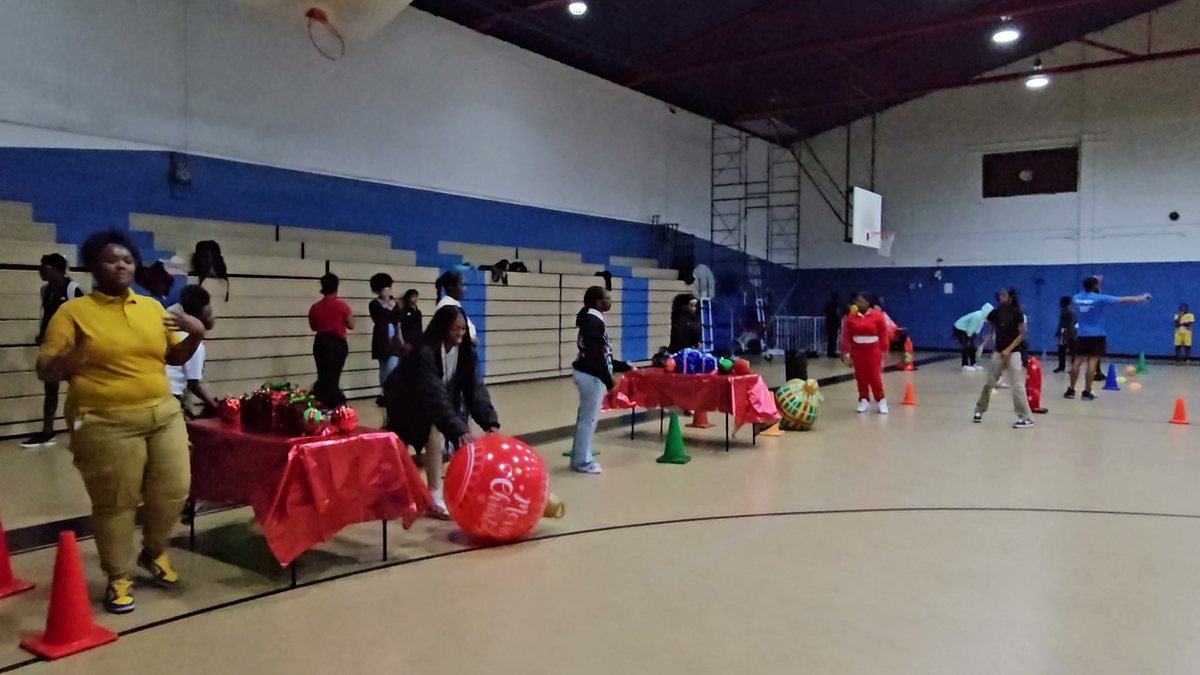 Crazy Games FL holiday games set up in a school gym with gift tables, giant ornaments and cones