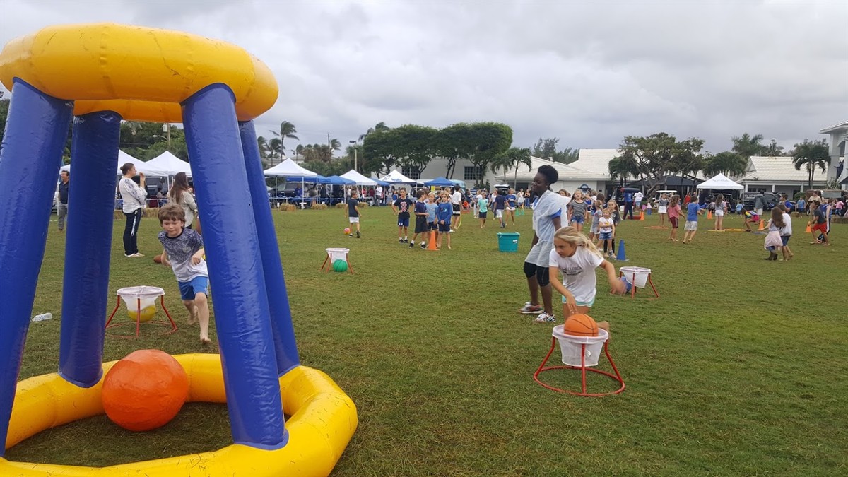 Giant inflatable Jumbo Basketball hoop and pumpkin-orange balls at a community field day