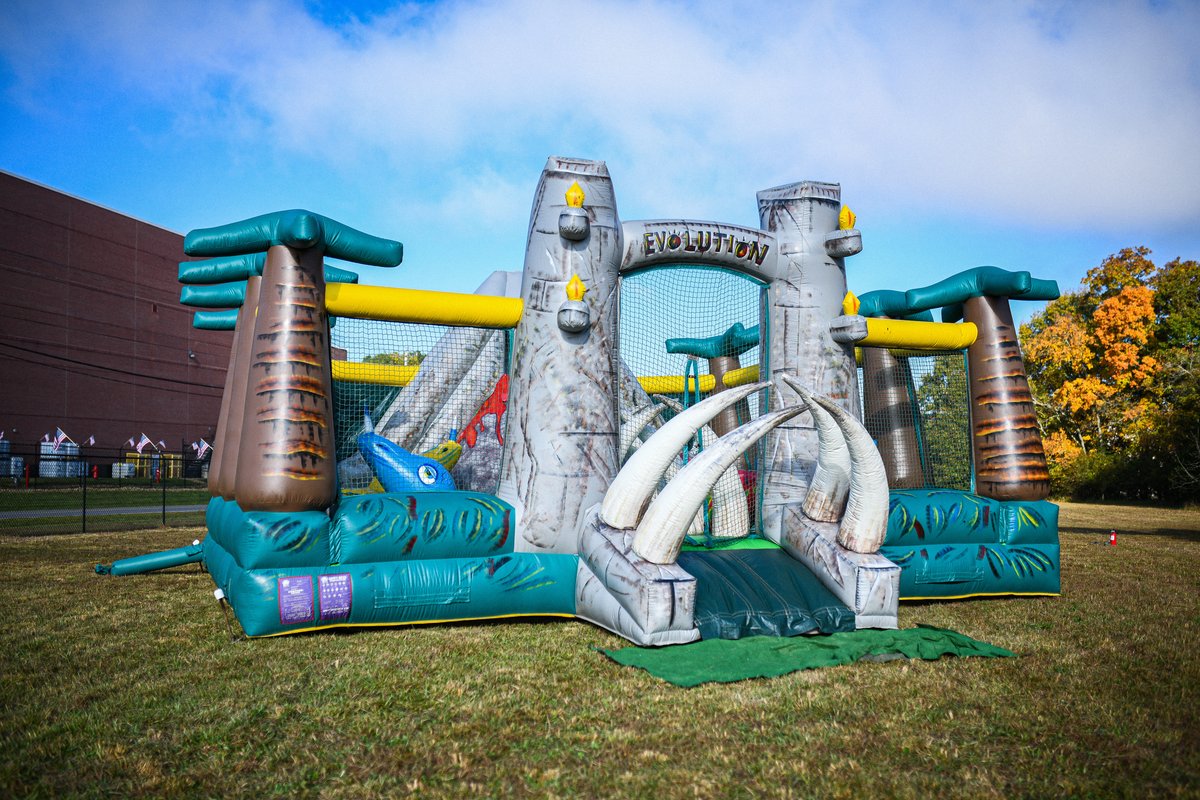 Crazy Games FL Jurassic Park Adventure obstacle course with rock wall set up on a wide school lawn