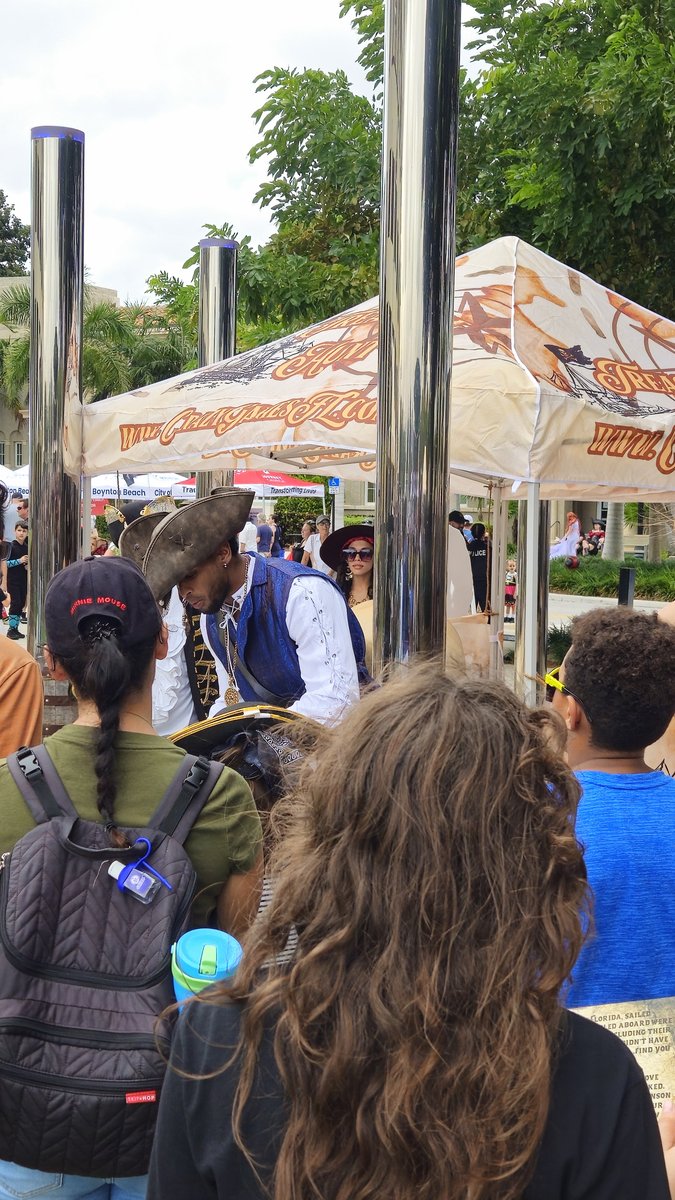 Pirate guide in costume leading a group of kids on a treasure hunt at an outdoor event