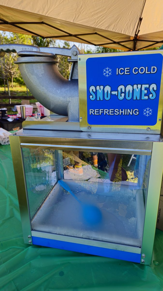 Crazy Games FL snow-cone machine set up on a table under a party tent at an outdoor event in South Florida