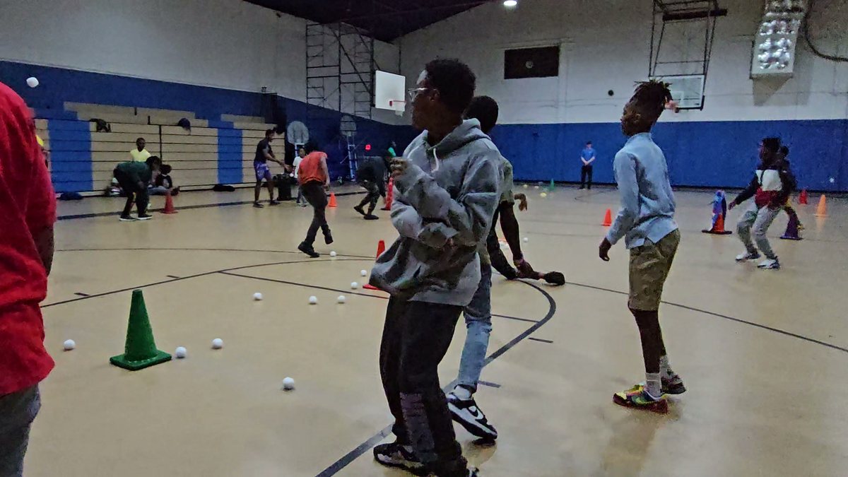 Students playing the Crazy Games FL Snowball Fight holiday game with soft snowballs and cones in a school gym